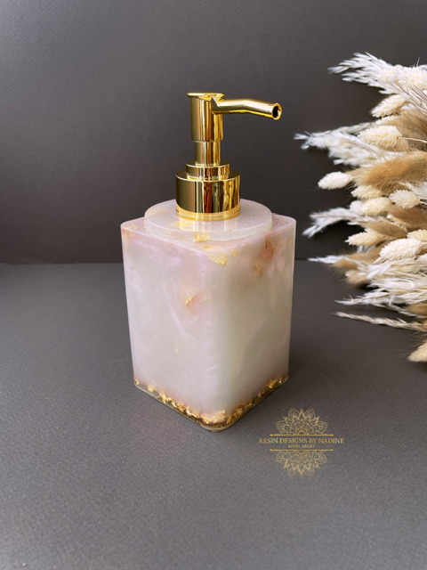 Pink soap dispenser with a gold pump